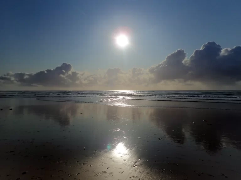 Photo of the Sun shine reflecting on the wet sand of the foreshore at Cabarita in Northern New South Wales, Austrlaia.